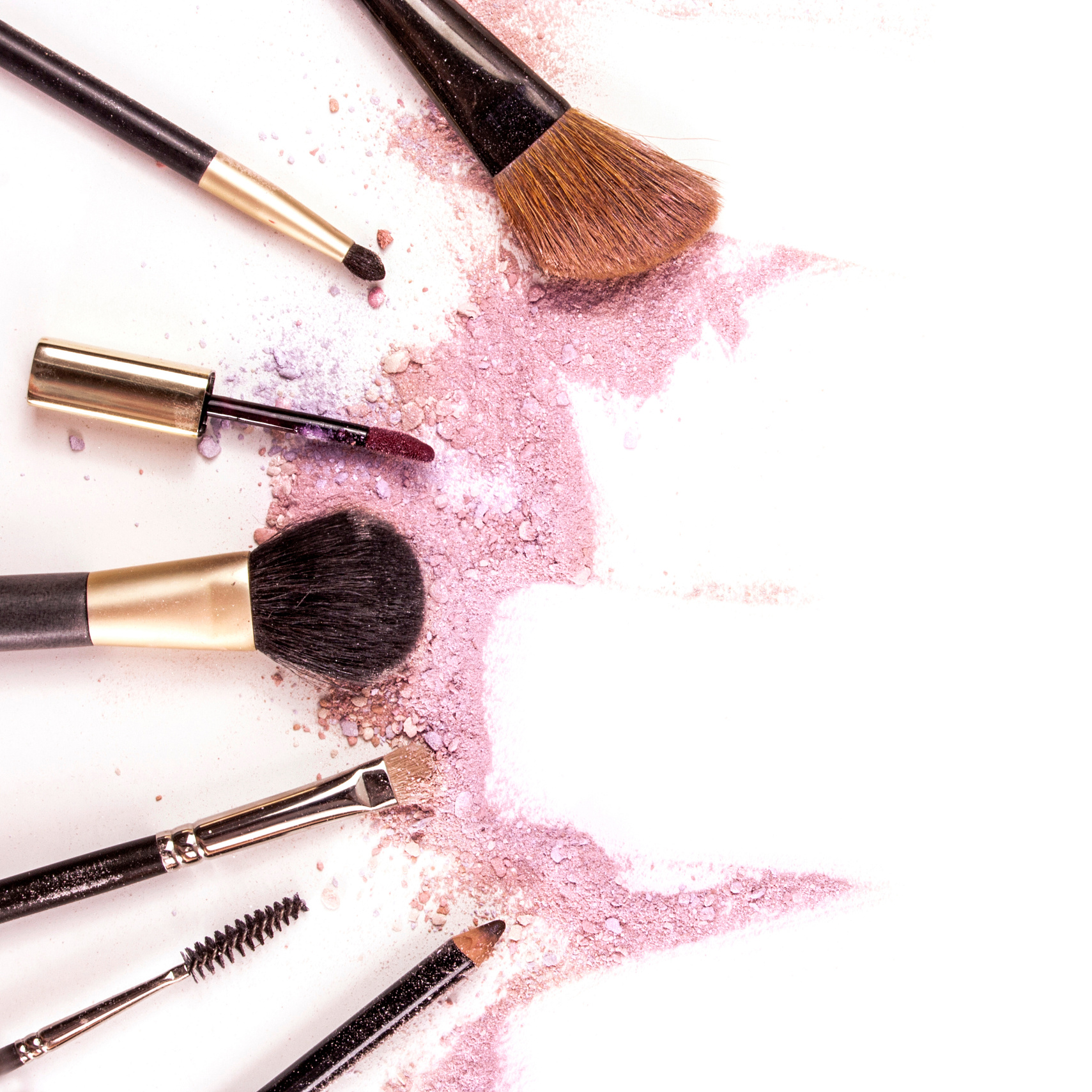 Makeup brushes, lip gloss and pencil on white background